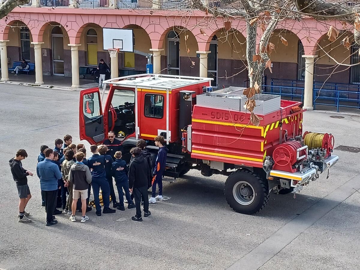 Des élèves autour d'un camion-citerne feux de forêt des pompiers, dans la cour de l'établissement