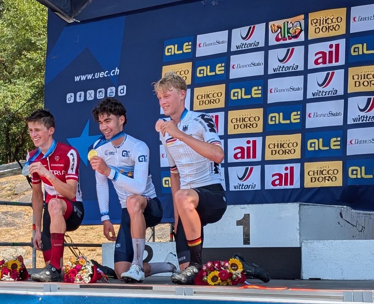 Podium des championnats d'Europe VTT 2026, trois coureurs médaillés devant le panneau de l'Union européenne de cyclisme