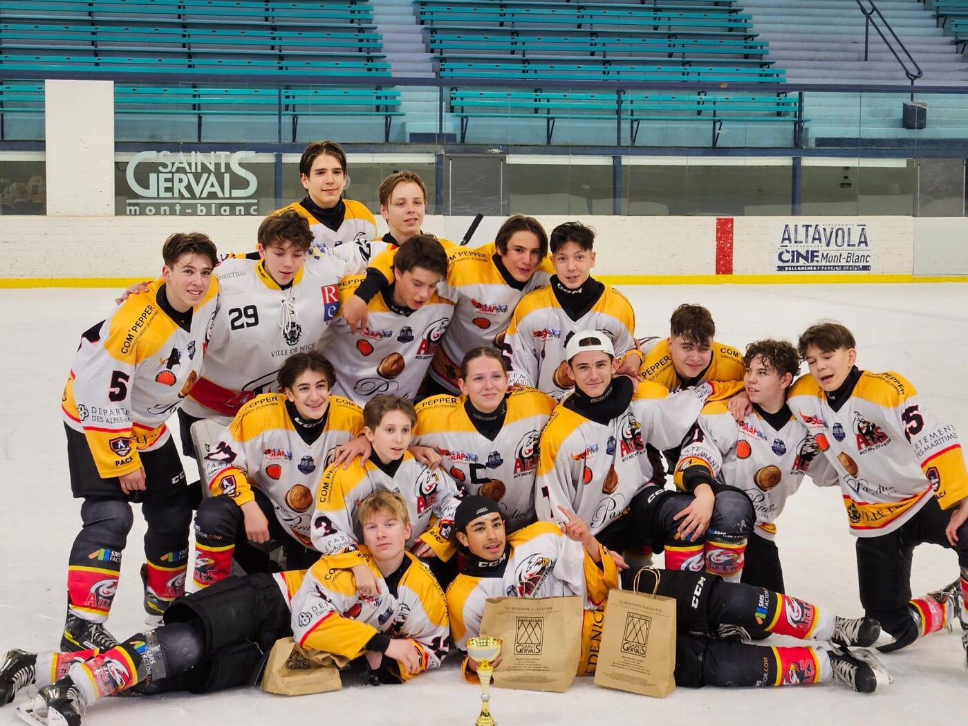 L’équipe de hockey sur glace réunie sur la patinoire avec son trophée
