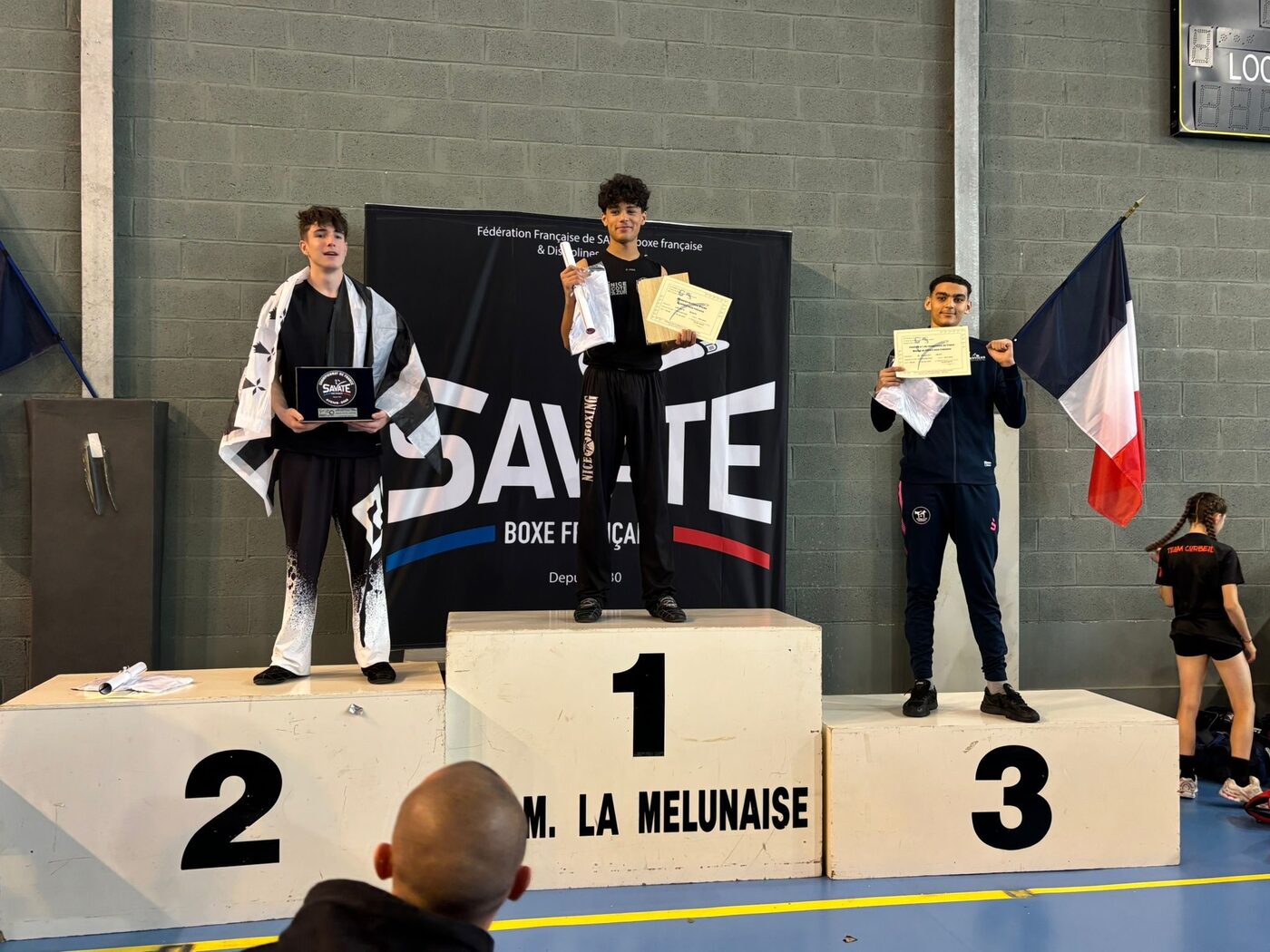 Trois jeunes sur le podium d’une compétition de savate boxe française