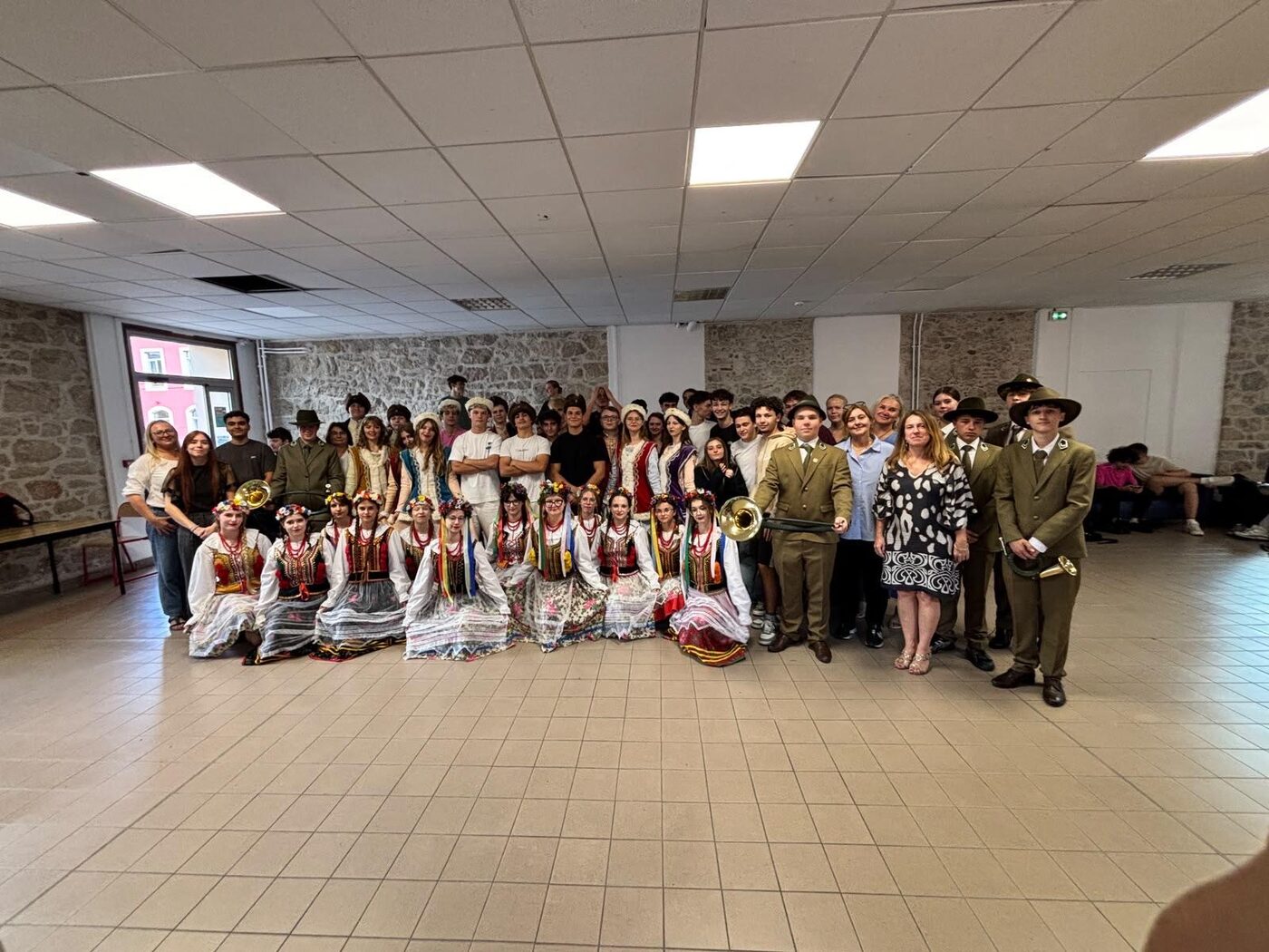 Danseurs en costume traditionnel et élèves de Don Bosco réunis dans une salle